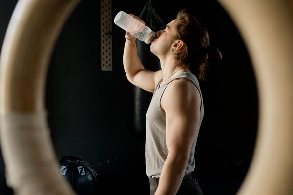 Male athlete performing rhythmic strength exercises in dark gym