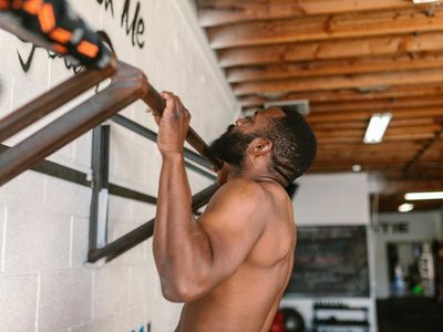 Shadow of a man doing pull ups against a wall